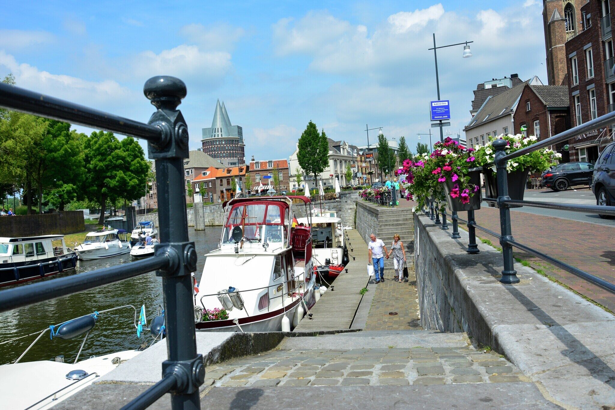 Ein Kanal mit Booten, einer Brücke und Gebäuden im Hintergrund.