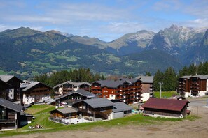 A mountain resort with chalet-style buildings, ski lifts, and a view of the surrounding mountains. - Peaceful Mountain Apartment in Morillon (Morillon)