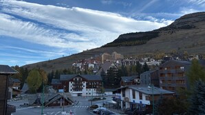 A town with a mix of modern and traditional buildings, a clear sky, and a hilly backdrop. - Les Marmottes N°302 - 2P7 (Les Deux Alpes)