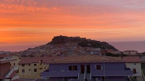 A coastal town with a prominent hilltop fortress, terracotta-roofed buildings, and a clear view of the sea at sunset. - Air conditioning, swimming pool and parking space (Castelsardo)