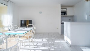 Una cocina moderna con armarios blancos, un microondas y un lavavajillas.