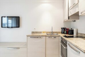 Eine moderne Küche mit eingebautem Backofen, Spüle und Geschirrspüler.
