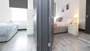 Un dormitorio moderno con cama, mesita de noche y lámpara.