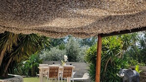 Une piscine avec une terrasse en bois et une table entourée de chaises.