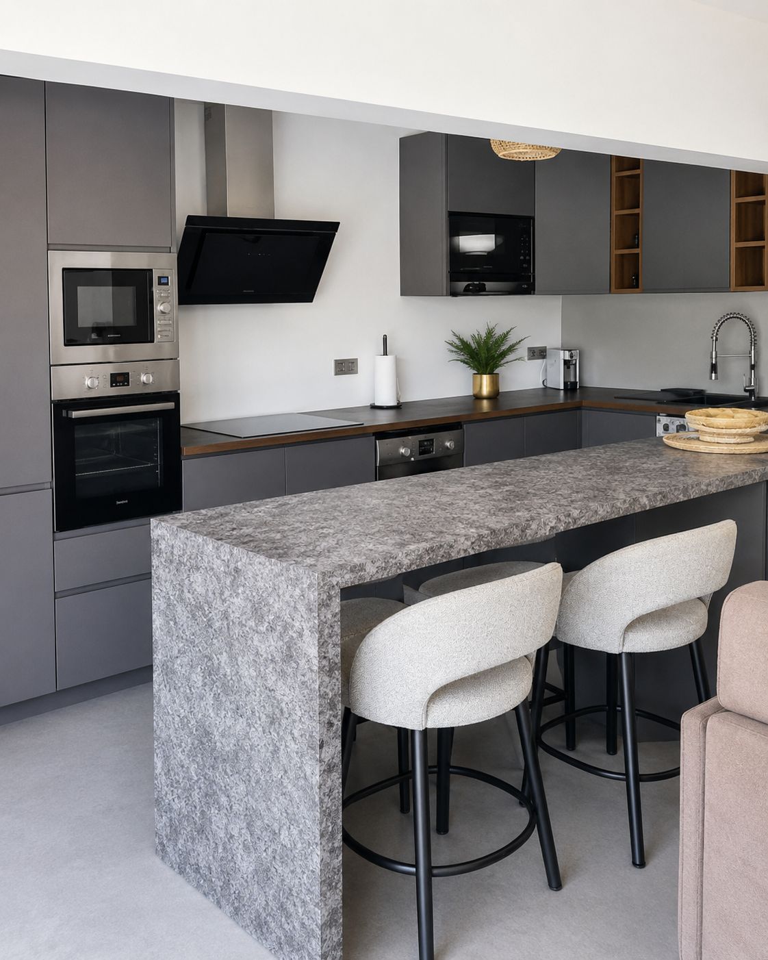 A modern kitchen with a granite countertop, stainless steel appliances, and bar stools.