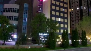 A hotel with a modern design, featuring a prominent sign and multiple floors. - Sapar Deluxe Plaza (Almaty)