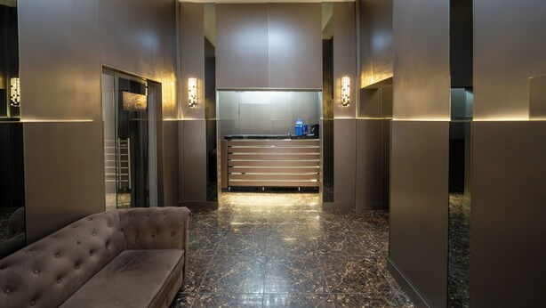 A modern lobby with a sofa, a reception desk, and a marble floor. - Sapar Deluxe Plaza (Almaty)
