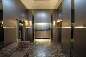 Eine moderne Lobby mit einer Couch, einem Empfangsbereich und einem Marmorboden.