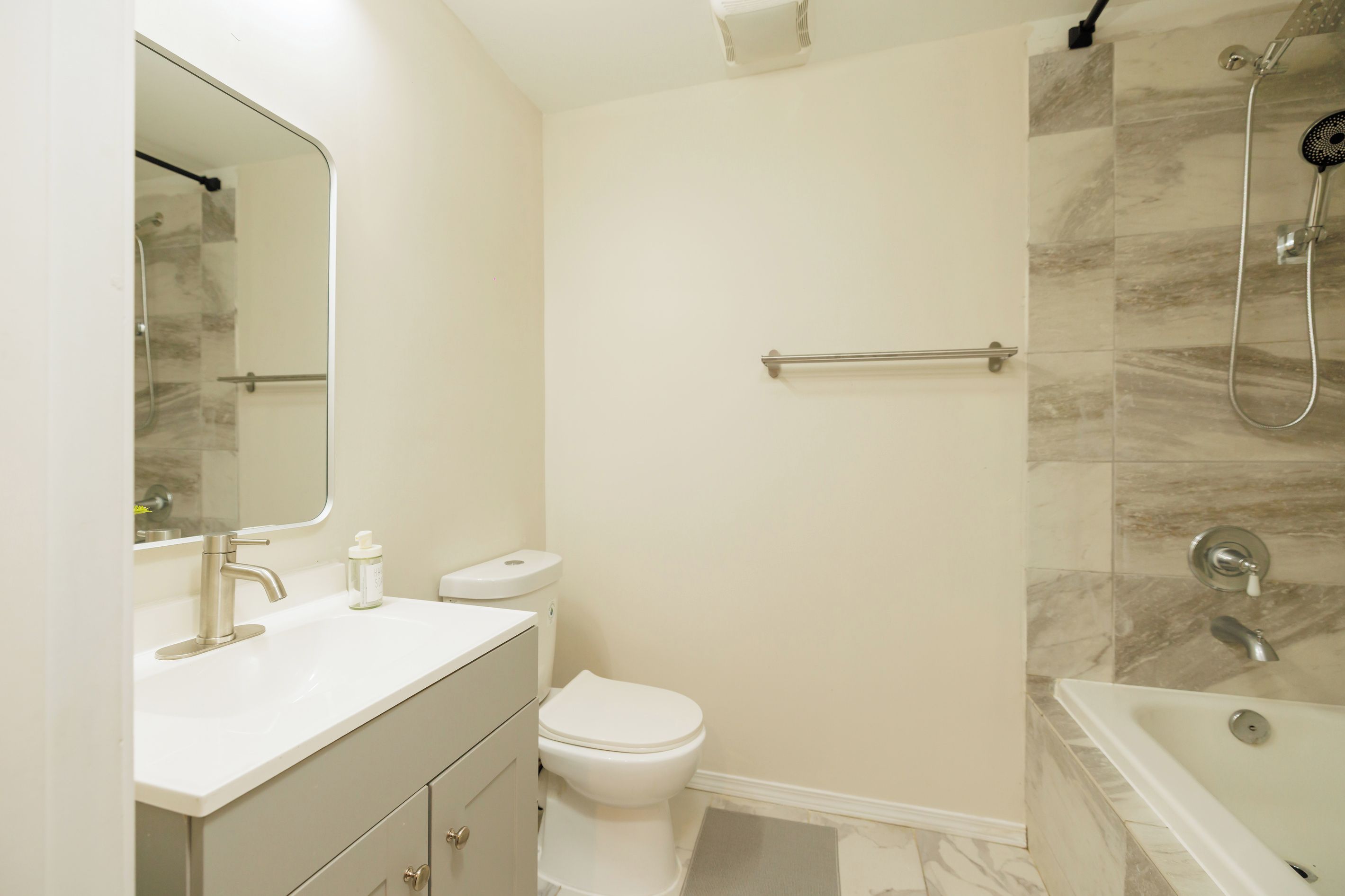 A bathroom with a toilet, sink, and shower.