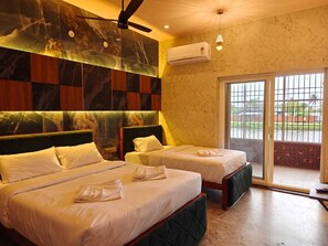 A hotel room with two beds, a ceiling fan, an air conditioning unit, and a view through a glass door. - Estuary Dreamz BOATEL (Puducherry)