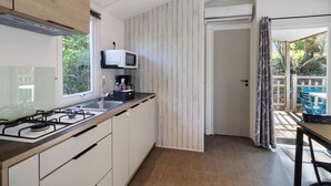 Una cocina moderna con estufa a gas, microondas y alacenas.