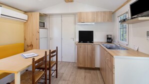 Une cuisine de taille réduite, dotée de meubles en bois, d’un four à micro-ondes, d’une cuisinière et d’un évier.