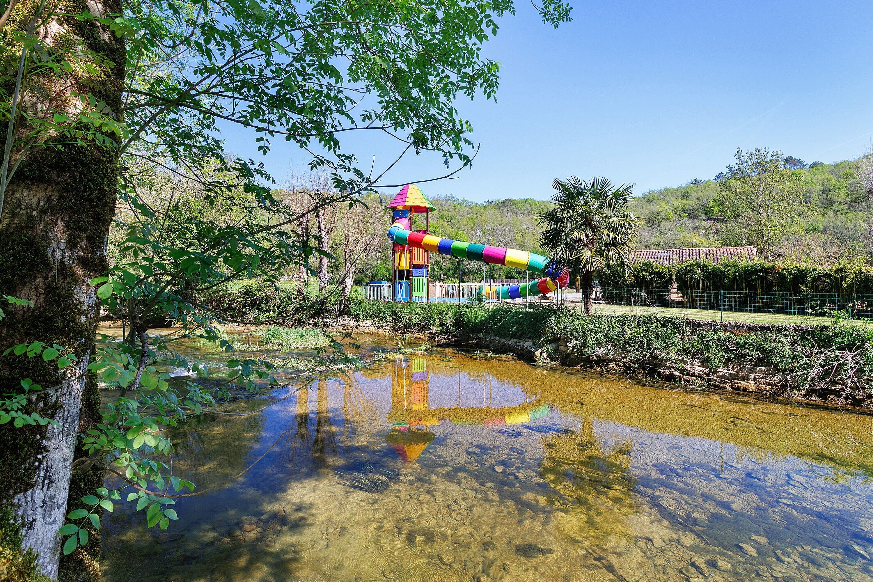 A playground with a colorful slide and a small water feature.