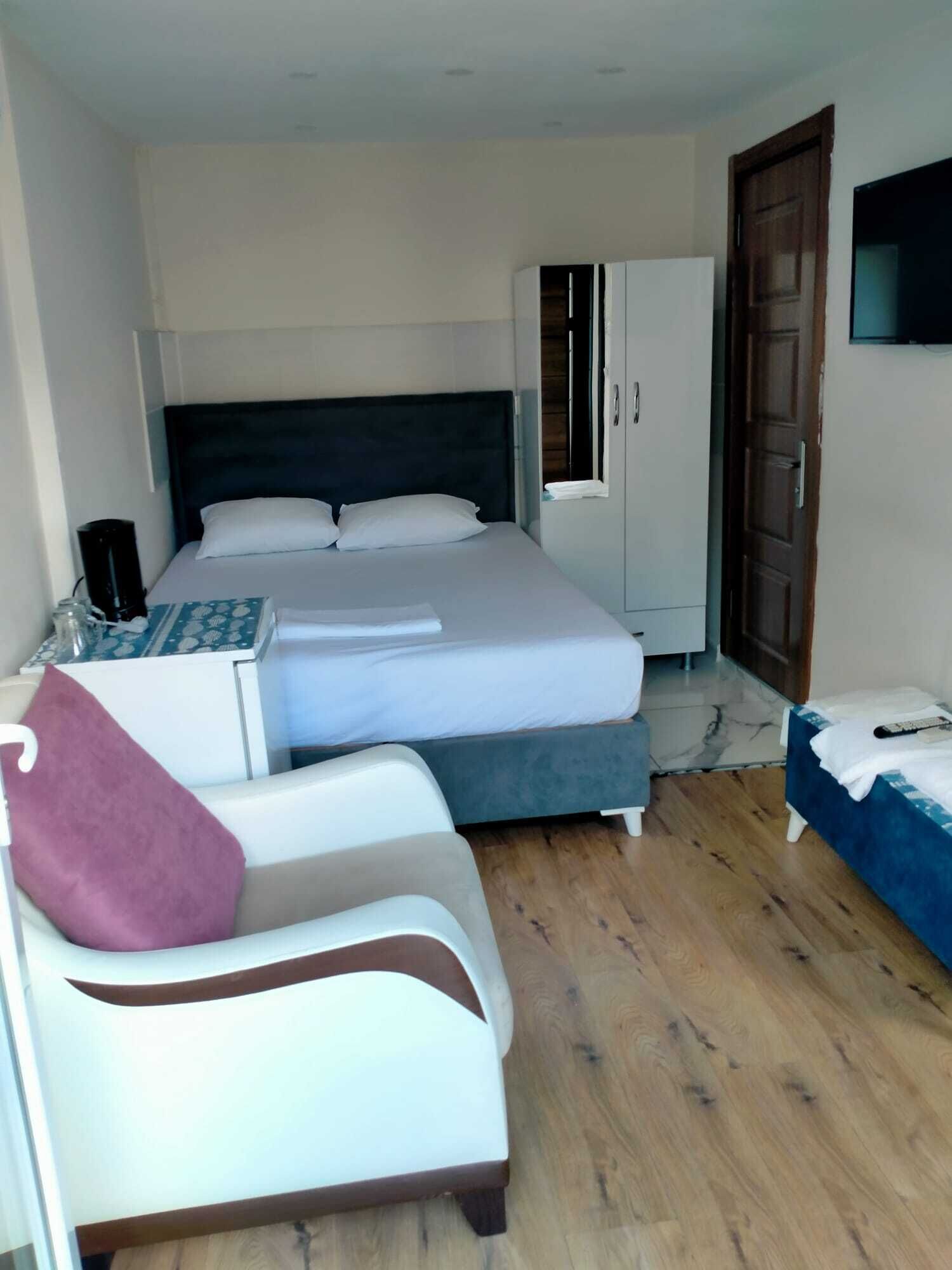 Une chambre d’hôtel équipée d’un lit, d’un bureau, d’une chaise, d’une armoire et d’un téléviseur.