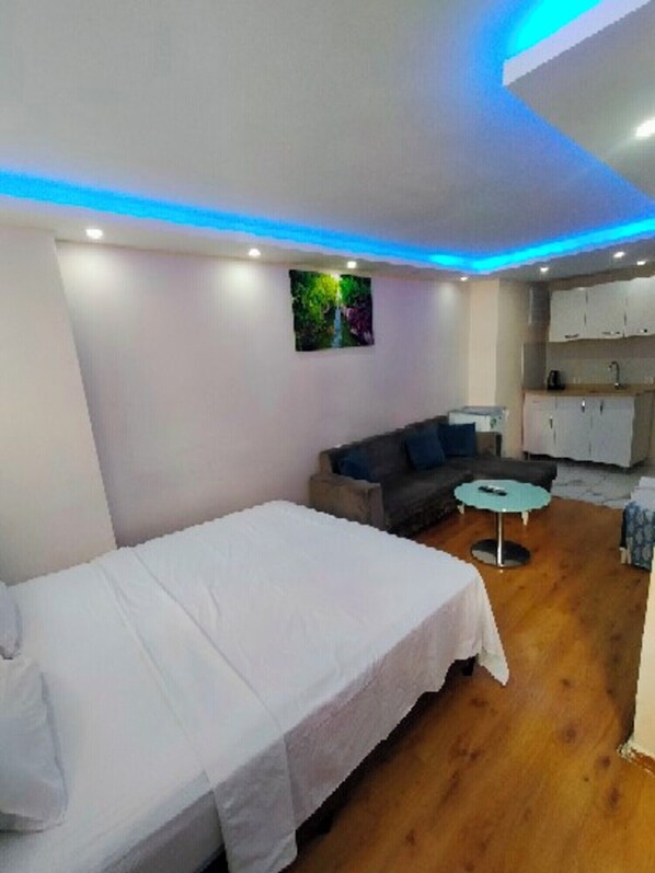 A room with a bed, a sofa, a small round table, and a kitchenette. - BlueRoyal Grand Bazaar (Istanbul)