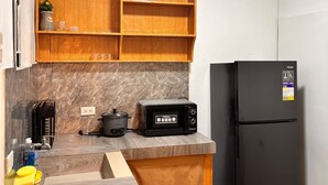A compact kitchen with a wooden countertop, a black toaster oven, a black refrigerator, and a marble backsplash. - Axon Cozy Modern House Grey Near The Walking Street (Angeles)