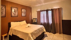 A hotel room with a bed, a nightstand, a wall-mounted air conditioner, and a window with curtains. - Axon Cozy Modern House Grey Near The Walking Street (Angeles)