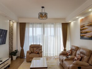 Departamento clásico, balcón, vista a la ciudad | Área de sala de estar | Televisión de plasma de 50 pulgadas con canales por cable y Netflix