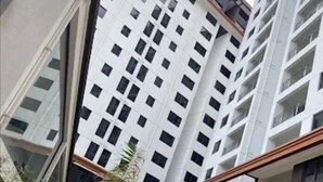Un edificio residencial de varios pisos con diseño moderno, con balcones y ventanas amplias.