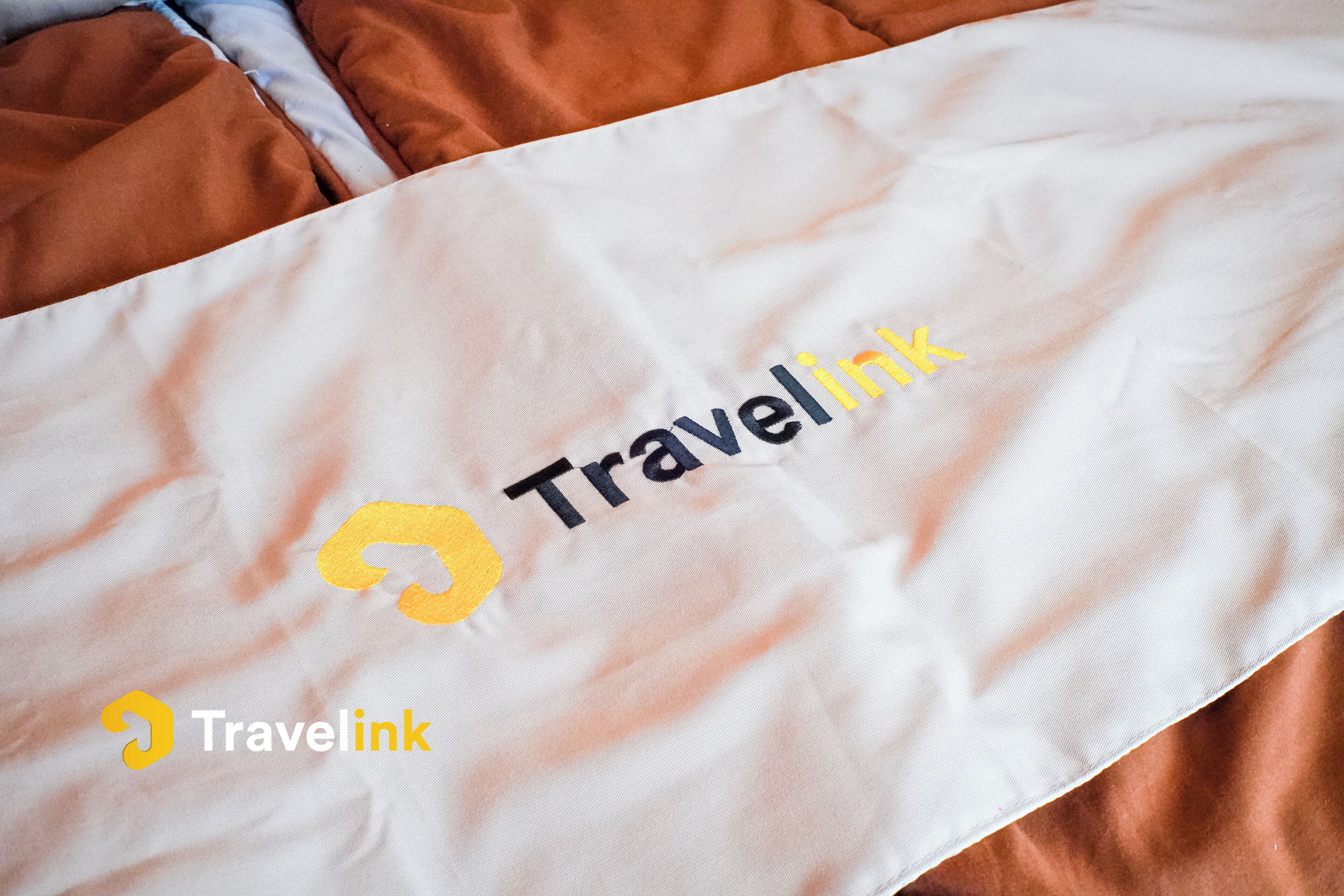 A white fabric with the Travellink logo and text.