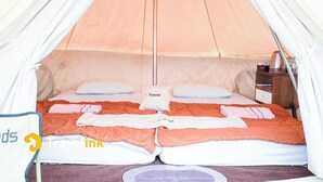 A tent with a bed, pillows, and a small table with a kettle. - Sun CampGround (Garung)