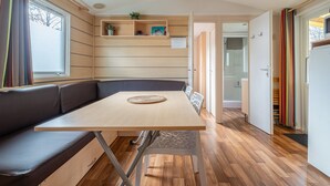 Una habitación moderna con una mesa de madera, un banco y un estante empotrado con una planta.