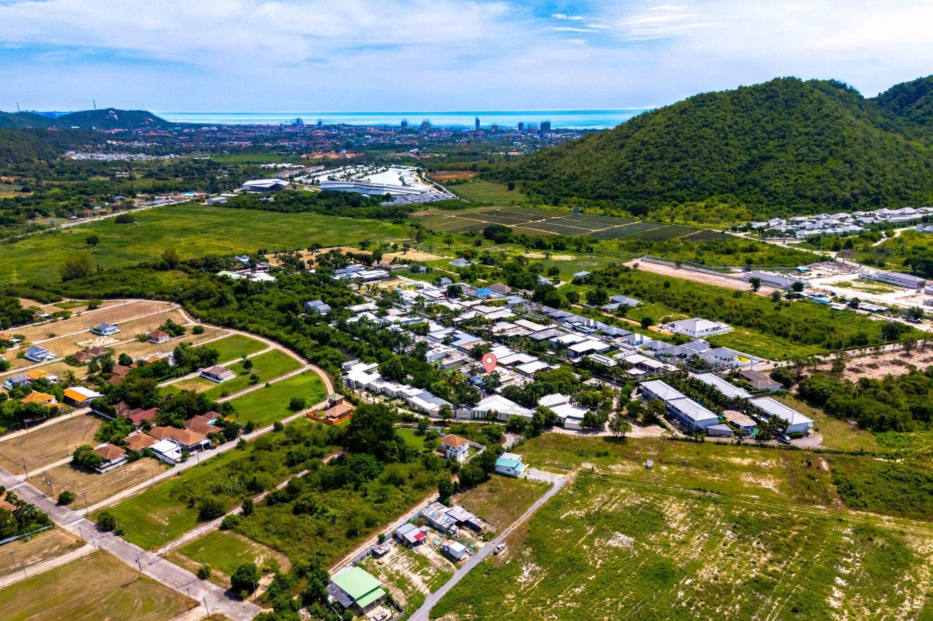 Vista aérea de um bairro residencial com casas, ruas e um grande conjunto de edifícios.
