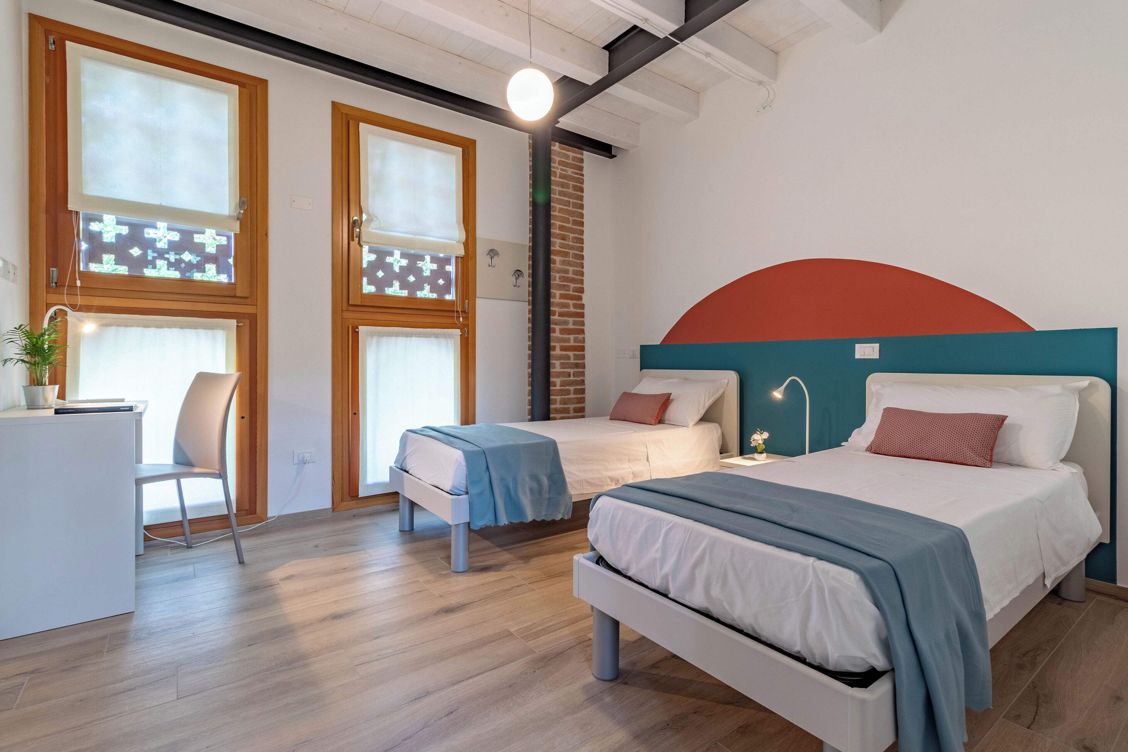 Une chambre moderne avec deux lits, un bureau et une chaise.