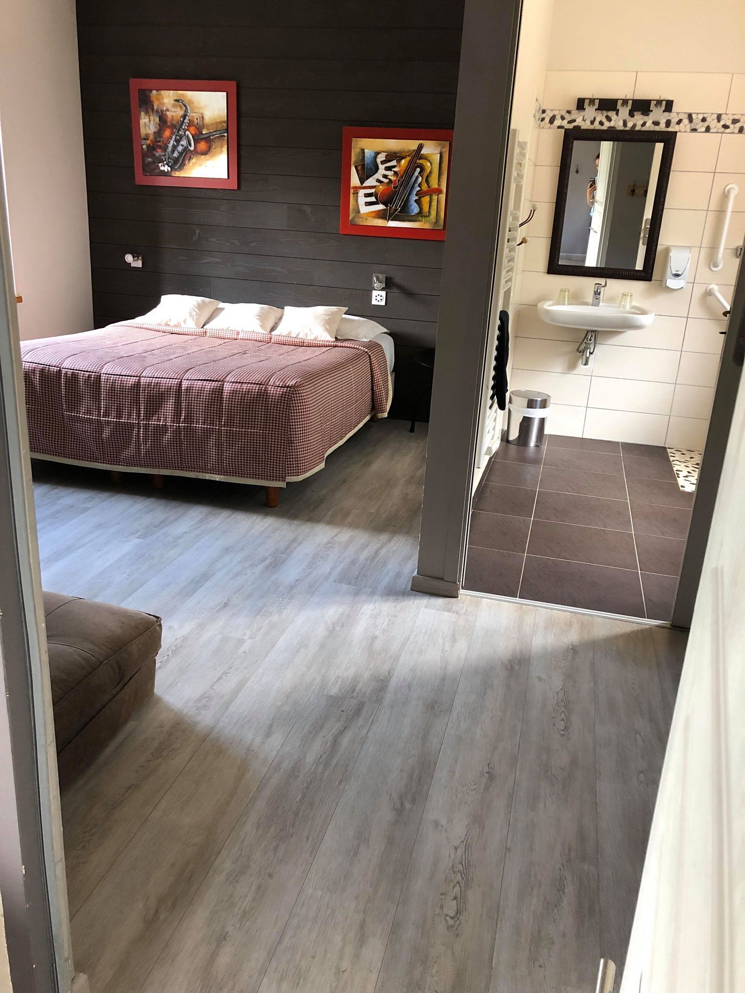A bedroom with a bed, a bedside table, a nightstand, and a wall-mounted TV.