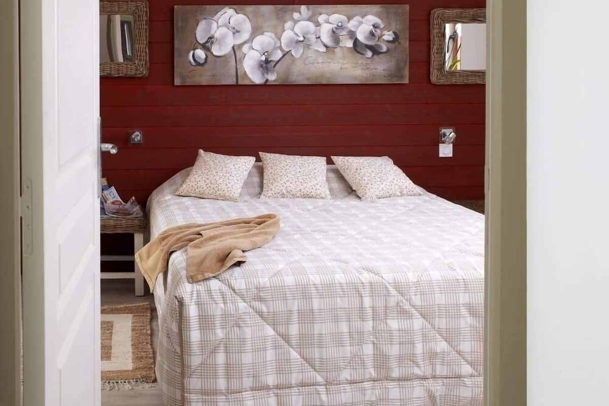 Ein Schlafzimmer mit Bett, Kissen, Decke und einem Bild an der Wand.