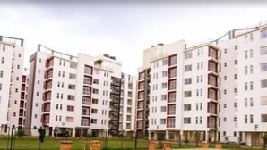 Ein moderner Apartmentkomplex mit mehreren Gebäuden, jedes mit Balkonen und einem einheitlichen architektonischen Stil.