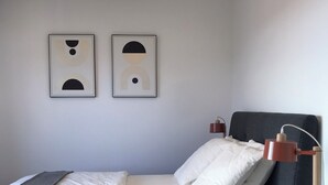 A modern bedroom with a bed, bedside tables, a lamp, and two abstract wall art pieces. - Blue Pearl A102 by Avecoeur (Nice)