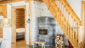 A cozy room with a fireplace, wooden staircase, and a bed. - Kultaranta ii by Interhome (Inari)