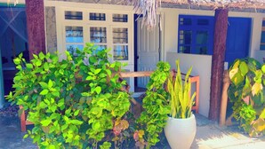 Une maison avec un toit de chaume, une porte en bois et une fenêtre donnant sur la mer.