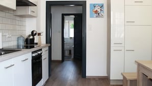 Una cocina moderna con armarios blancos, horno negro y encimera de madera.