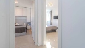 A modern bedroom with a bed, bedside table, and a wardrobe. - Nova Excellence apartment (Novalja)