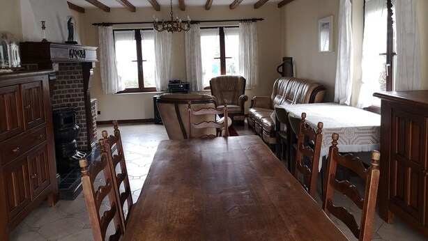 A spacious room with a wooden dining table, leather seating, and a chandelier. - Vacation home Bornem, quiet location. Close to Ghent, Antwerp, Mechelen, Puurs (Bornem)