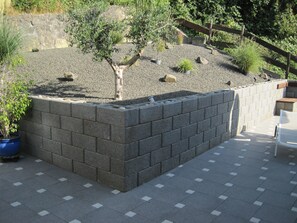 A garden with a stone wall, potted plants, and a bench. - 5 star apartment to feel good with 2 bedrooms, quiet location. (Kleinblittersdorf)