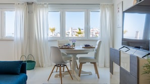 Une cuisine moderne avec un coin repas, de grandes fenêtres et une vue sur la ville.