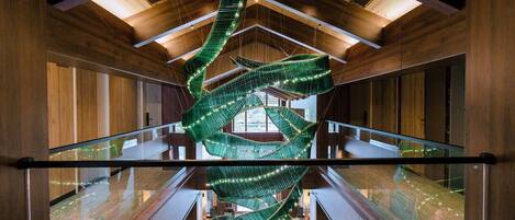 A modern interior with a spiral staircase, wooden paneling, and glass railings.