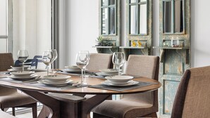 A dining area with a round table set for four, surrounded by chairs. - 2304 (Dubai)