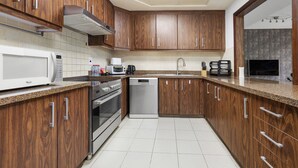 A modern kitchen with wooden cabinets, stainless steel appliances, and a tiled backsplash. - 2304 (Dubai)