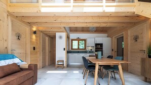 Un interior de madera con comedor, cocina y sofá.