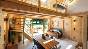 Un interior espacioso con una escalera de madera, un comedor y una zona de estar acogedora.