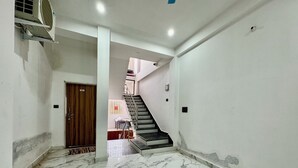 A hallway with marble flooring, a staircase, and a door labeled "101". - Hotel radha Aradhya Sadan (Mathura)
