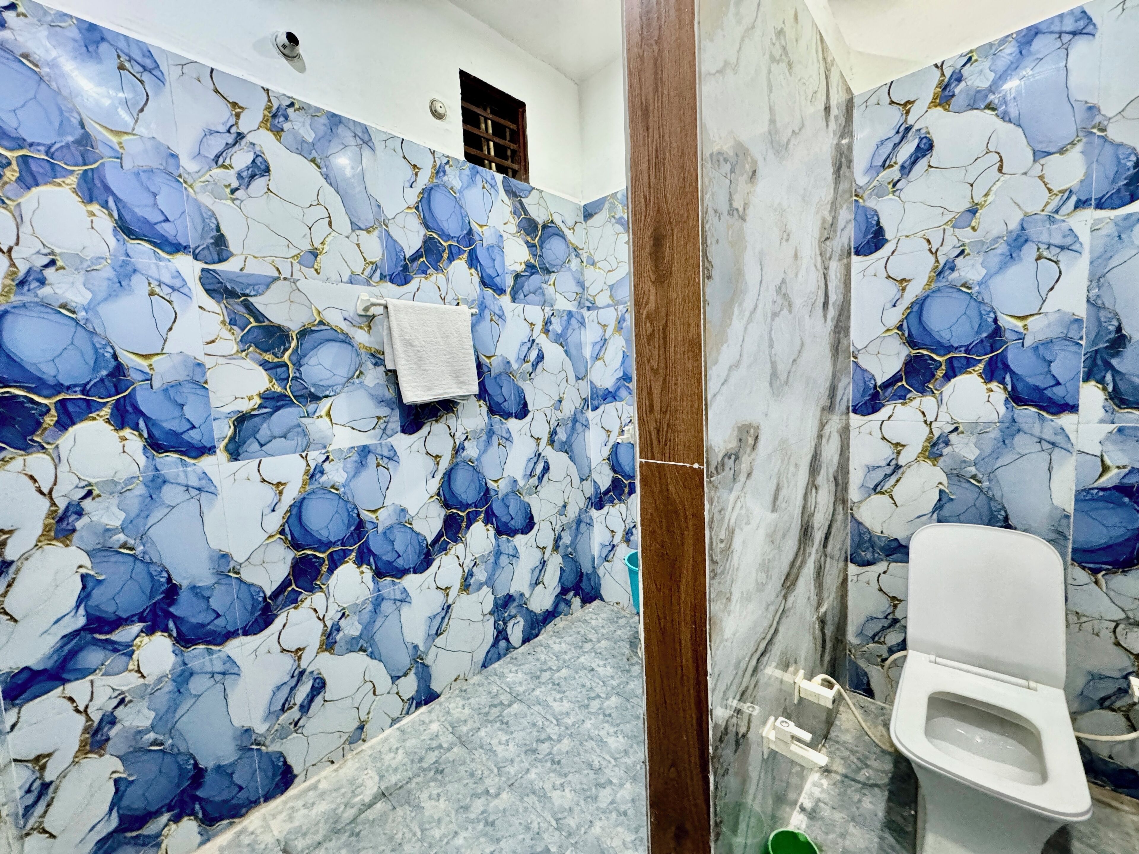A bathroom with marble walls and a toilet.