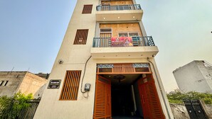 A multi-story building with a flat facade, balconies, and a signboard. - Hotel radha Aradhya Sadan (Mathura)