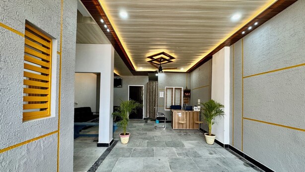 A hallway with a reception desk, potted plants, and a seating area. - Hotel radha Aradhya Sadan (Mathura)