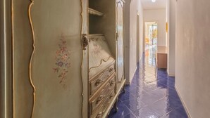 A hallway with a large, ornate wardrobe, a mirror, and a blue-tiled floor. - Casa D'Amato - Maiori (Maiori)