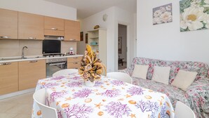 Una cocina moderna con armarios de madera, una mesa de comedor con mantel floral y un sofá floral.
